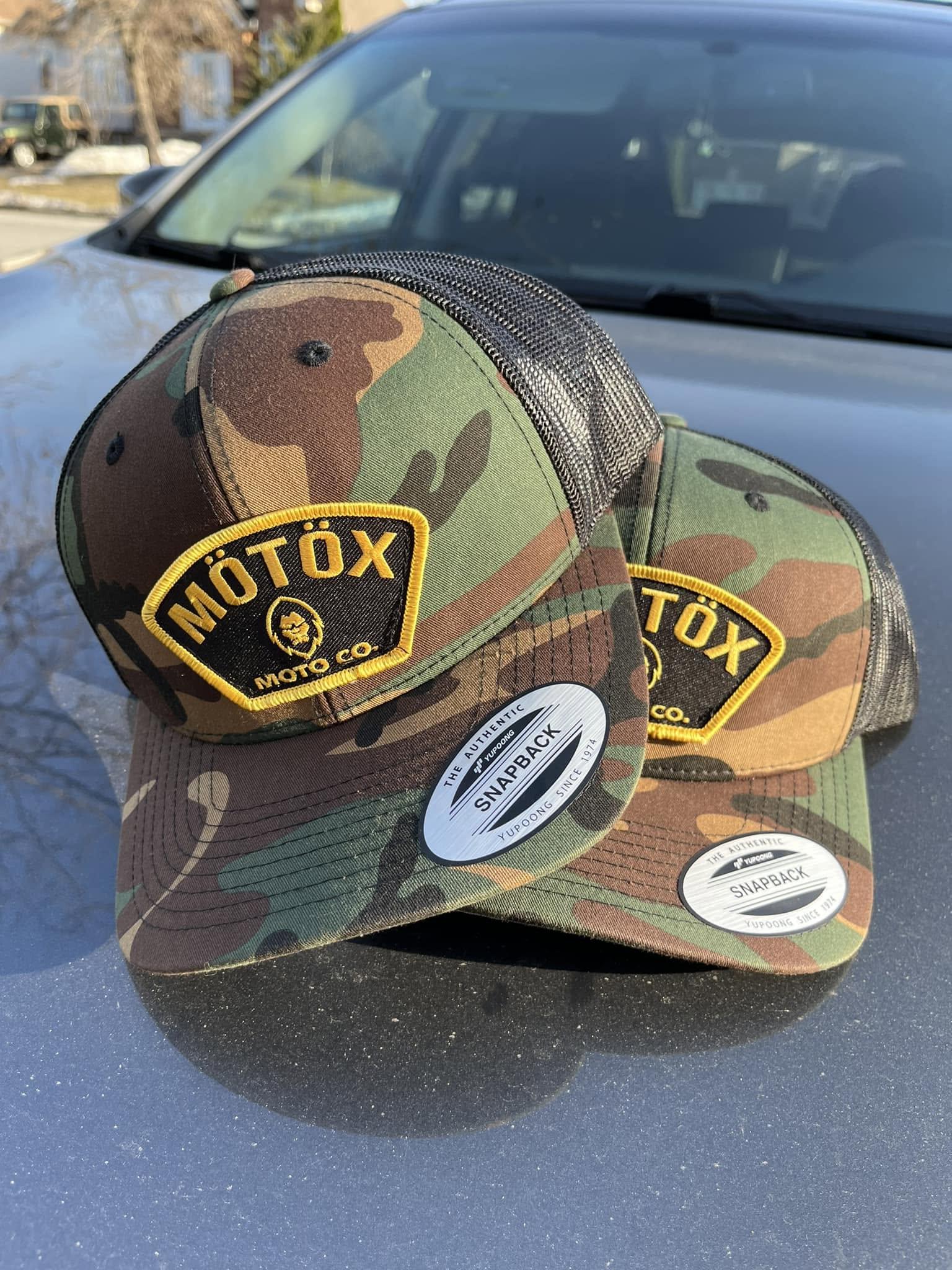 Two camouflage trucker hats with embroidered MÖTÖX Moto Co. patches